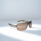 Close-up of Dior Diorlywood sunglasses showcasing engraved logo and brown gradient lenses